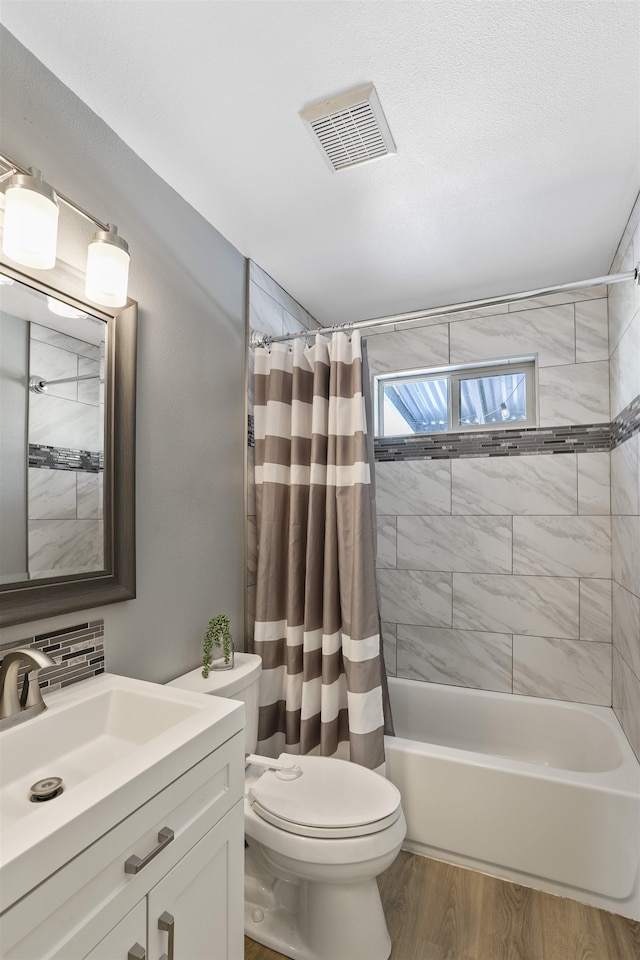 full bathroom featuring wood-type flooring, backsplash, vanity, toilet, and shower / bath combo with shower curtain