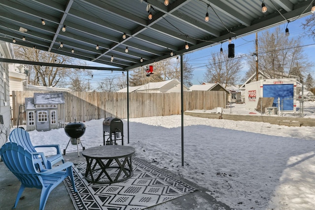 snow covered patio with a grill