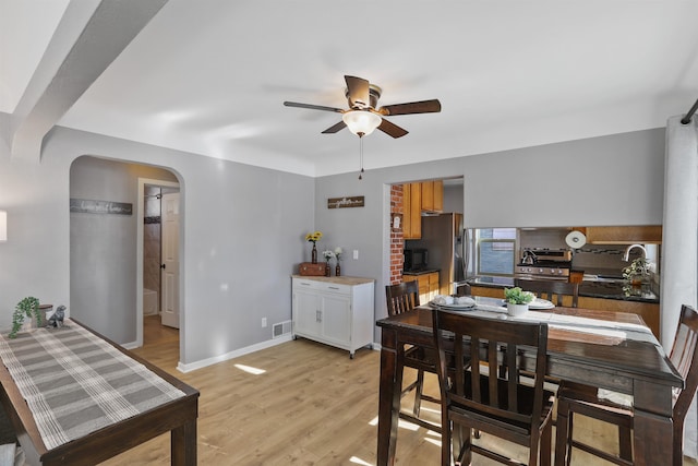 dining area with ceiling fan, light hardwood / wood-style floors, and sink