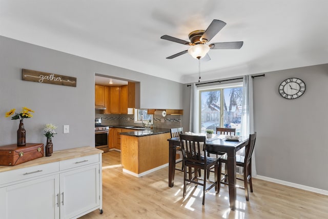 dining room featuring sink, ceiling fan, and light wood-type flooring