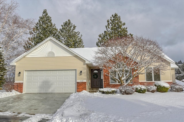 ranch-style house featuring an attached garage, driveway, and brick siding