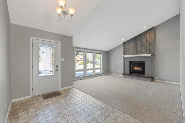 foyer featuring lofted ceiling, a fireplace, a chandelier, and light carpet