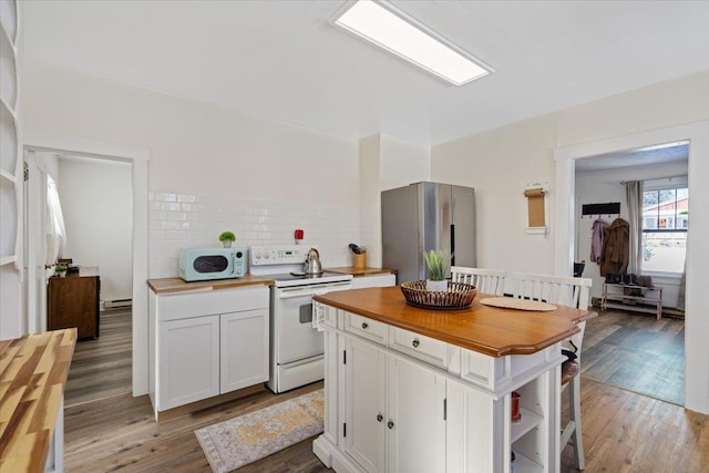 kitchen with butcher block countertops, white cabinets, and white appliances