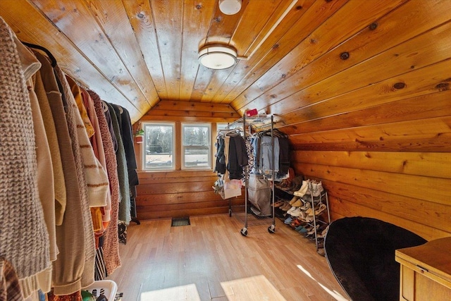 walk in closet with vaulted ceiling and light hardwood / wood-style floors