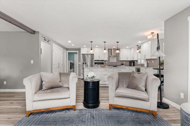 living room with washer / dryer and light hardwood / wood-style flooring