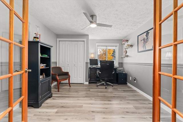 office space featuring ceiling fan, a textured ceiling, light hardwood / wood-style floors, and french doors