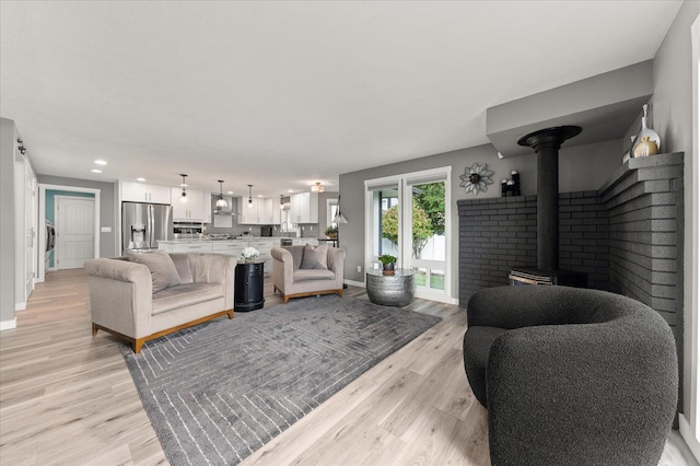 living room with a wood stove and light wood-type flooring