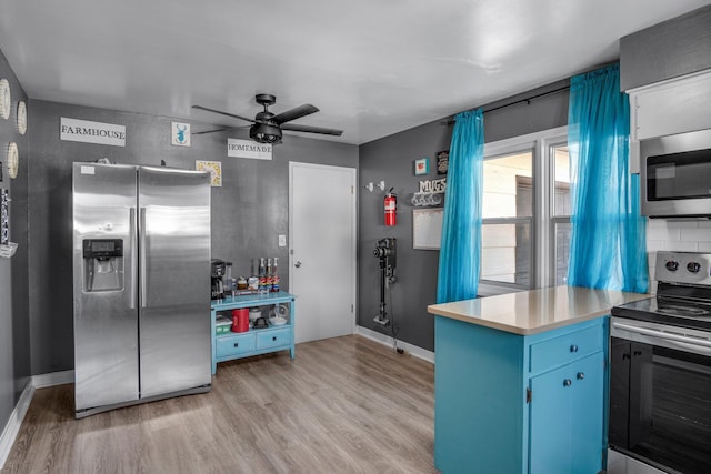 kitchen with stainless steel appliances, blue cabinetry, ceiling fan, and light hardwood / wood-style flooring