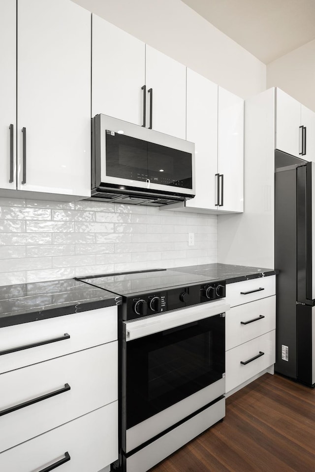 914 E Deer Park-Milan Rd, Deer Park, WA 99006 - kitchen with stainless steel microwave, electric range oven, freestanding refrigerator, dark wood-style flooring, and white cabinetry