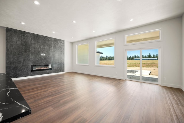 914 E Deer Park-Milan Rd, Deer Park, WA 99006 - unfurnished living room featuring a tiled fireplace, baseboards, recessed lighting, and wood finished floors