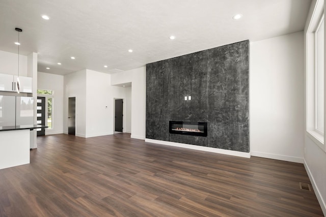 914 E Deer Park-Milan Rd, Deer Park, WA 99006 - unfurnished living room featuring recessed lighting, baseboards, dark wood-style flooring, and a fireplace