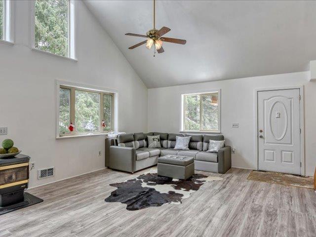 living room with light wood-type flooring, french doors, and ceiling fan