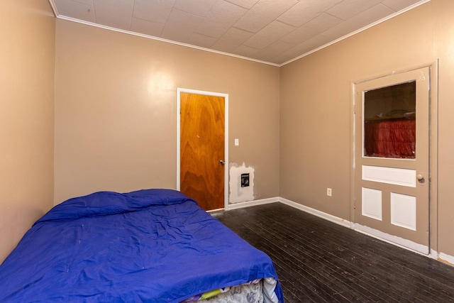 bedroom featuring dark wood-type flooring and crown molding