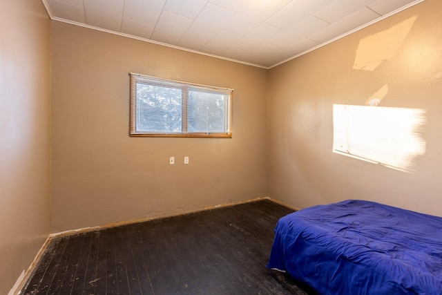 bedroom with ornamental molding and dark hardwood / wood-style flooring