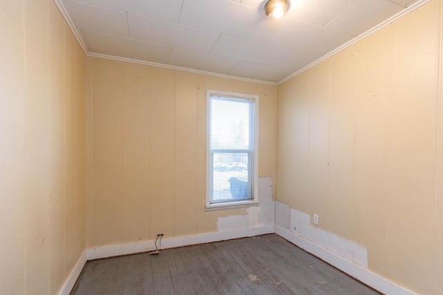 empty room with hardwood / wood-style flooring and crown molding