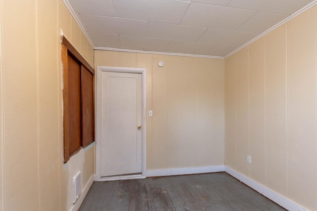 empty room with crown molding and hardwood / wood-style floors