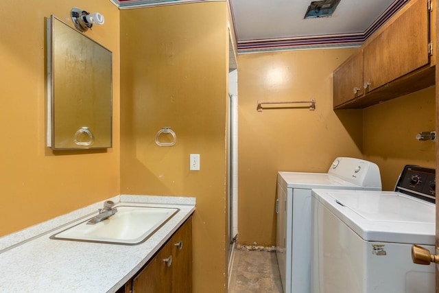 washroom with cabinets, washing machine and dryer, and sink