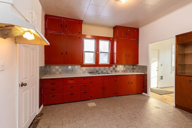 kitchen featuring sink, backsplash, and light parquet floors