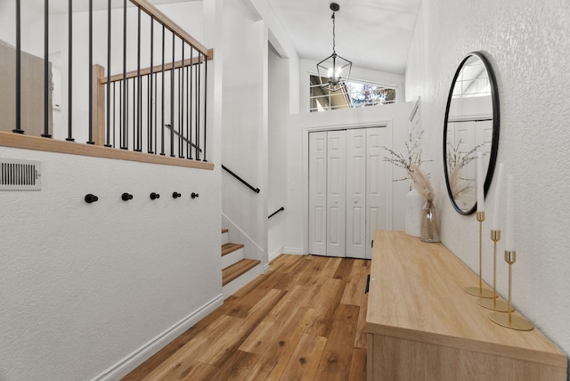 entrance foyer featuring hardwood / wood-style flooring and an inviting chandelier