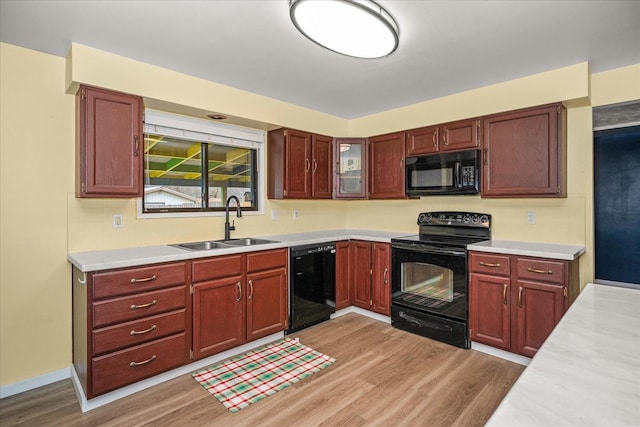 kitchen with sink, light hardwood / wood-style flooring, and black appliances