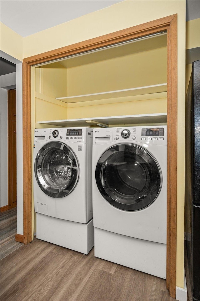 laundry area featuring washing machine and dryer and hardwood / wood-style floors