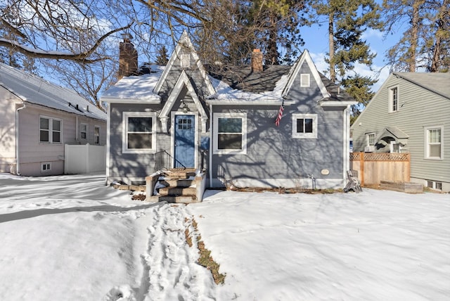 view of front of house featuring a chimney and fence