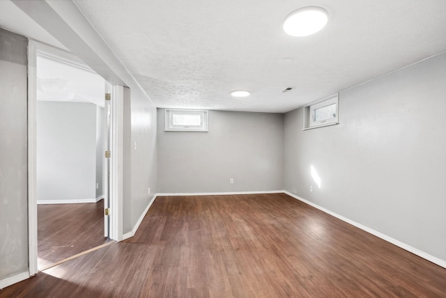 basement featuring dark hardwood / wood-style floors and a textured ceiling