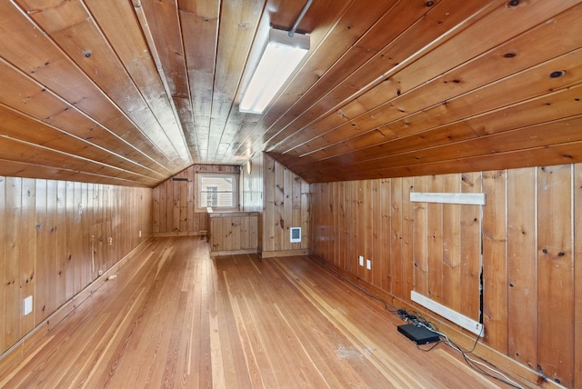 bonus room with vaulted ceiling, wooden ceiling, light wood-type flooring, and wood walls