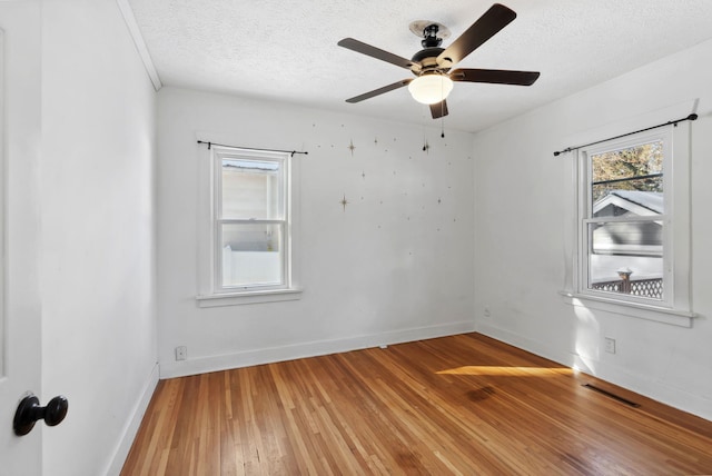 spare room featuring hardwood / wood-style flooring, ceiling fan, and a textured ceiling