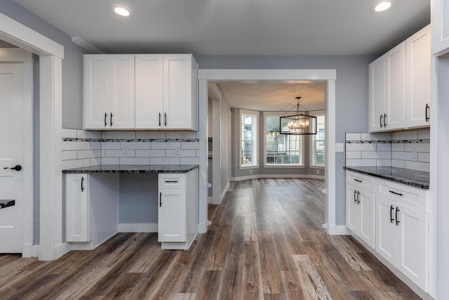 kitchen with white cabinetry, dark hardwood / wood-style floors, and dark stone counters