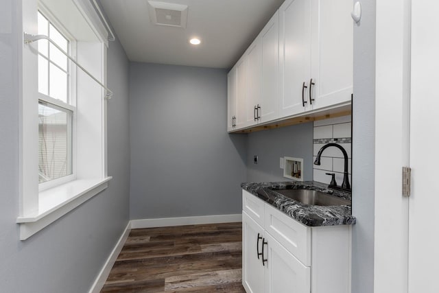 kitchen with white cabinetry, sink, dark stone countertops, and dark hardwood / wood-style flooring