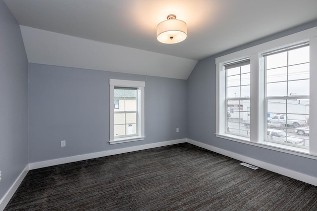 bonus room featuring lofted ceiling and dark colored carpet