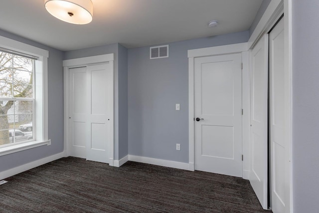 unfurnished bedroom with dark carpet