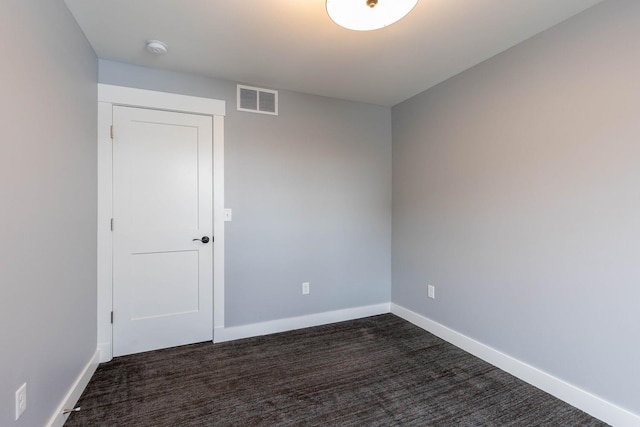 empty room featuring dark carpet