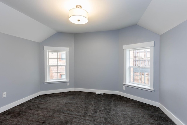 additional living space with lofted ceiling and dark colored carpet