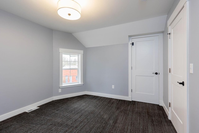 additional living space with lofted ceiling and dark colored carpet