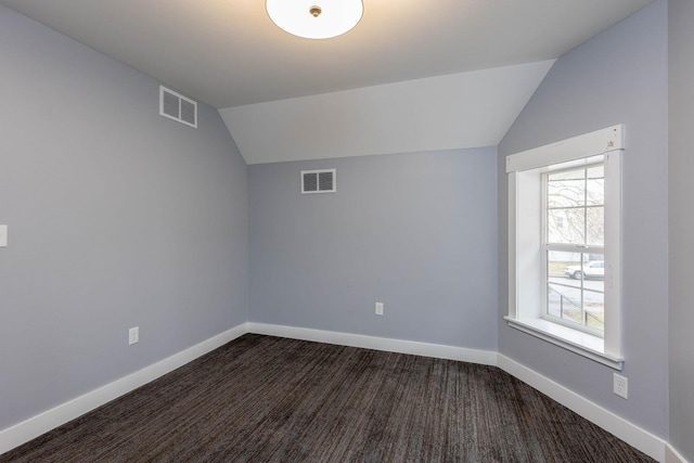 bonus room featuring lofted ceiling and dark carpet