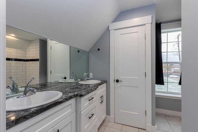 bathroom featuring tile patterned flooring, vanity, and lofted ceiling