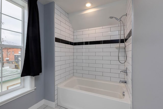 bathroom featuring a healthy amount of sunlight and tiled shower / bath combo