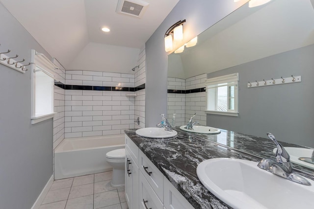 full bathroom with lofted ceiling, tile patterned floors, toilet, vanity, and tiled shower / bath combo