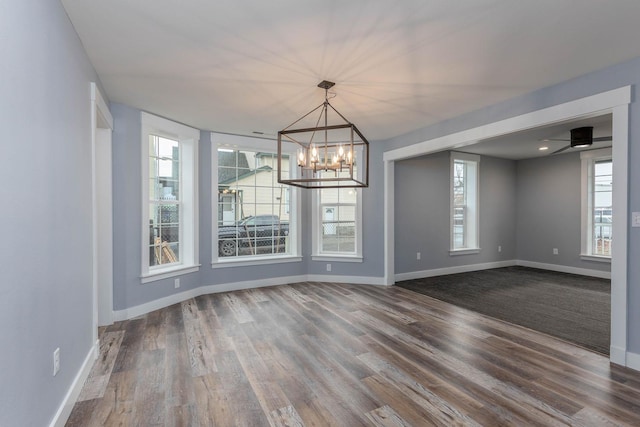 unfurnished dining area with hardwood / wood-style flooring and a chandelier