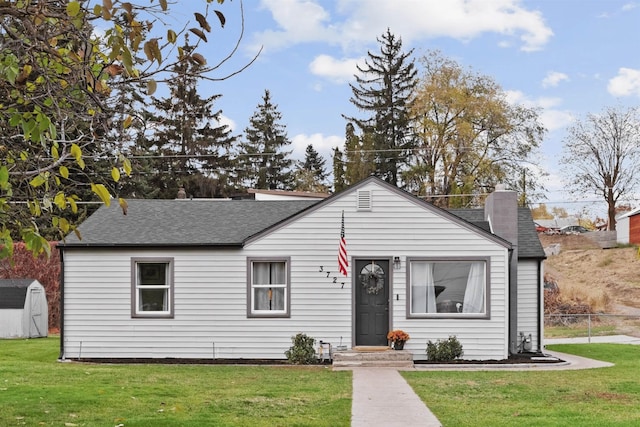 view of front of house with a shed and a front yard