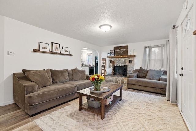 living room with a fireplace, hardwood / wood-style floors, and a textured ceiling