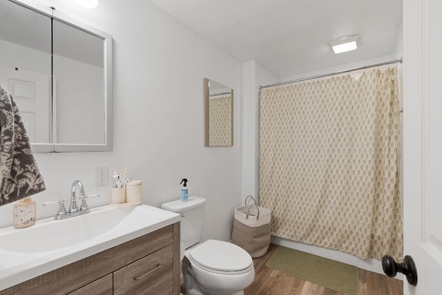 bathroom with vanity, toilet, and hardwood / wood-style floors