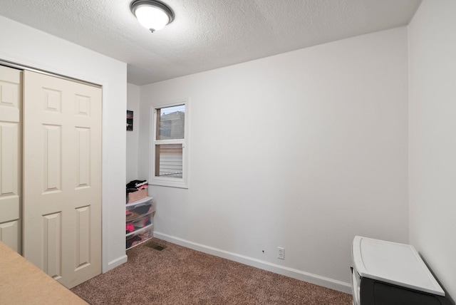 carpeted bedroom with a closet and a textured ceiling