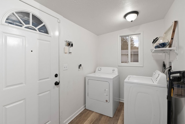 laundry area featuring independent washer and dryer, light hardwood / wood-style flooring, and a textured ceiling