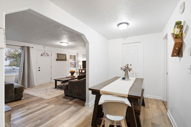 dining room featuring light hardwood / wood-style floors and a textured ceiling