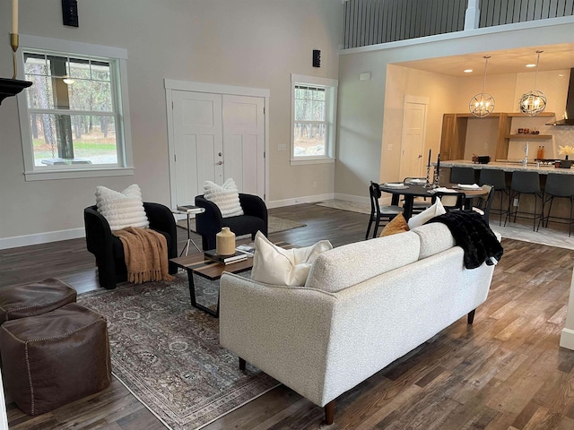 28411 N Milan Rd, Chattaroy, WA 99003 - living room featuring an inviting chandelier, a towering ceiling, and dark hardwood / wood-style flooring