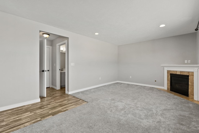 unfurnished living room with hardwood / wood-style flooring and a tile fireplace