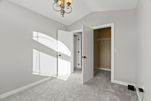 unfurnished bedroom with light colored carpet, lofted ceiling, a closet, and a walk in closet